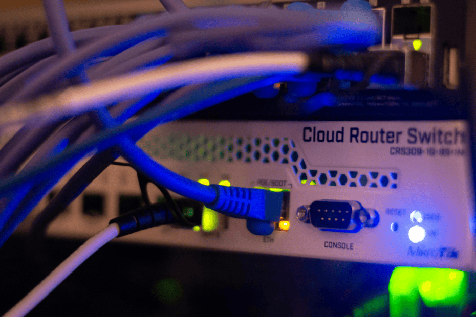 Networking hardware and data cables configured in a server rack for a live system migration.
